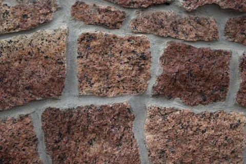 Stone background of red-orange marble with cement between stones. Stone tex.. Stock Illustration