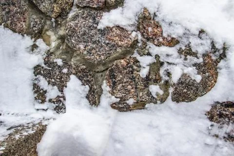 A stone background in the snow. Texture. Stock Photos