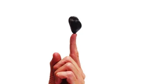 Stone balancing on a finger Stock Photos