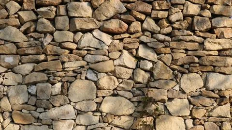 Stone barrier made of rough cobblestones, full frame Photos