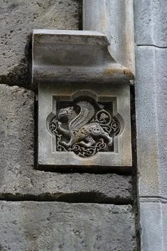 Stone bas-relief with a griffin built into the wall. Stock Photos
