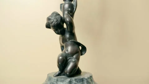 Stone Base Bronze Candlestick - Angel on a glass table. Shot in motion Stock Footage 121604461