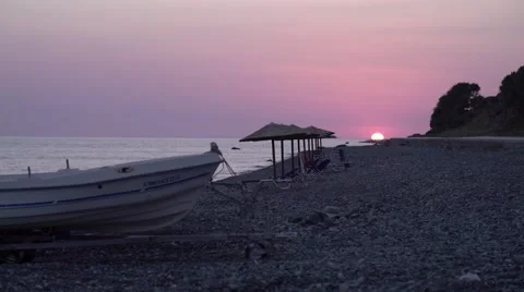 Stone Beach with Boat at Sunset 4K Stock Footage 67396777