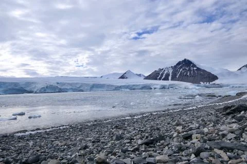 Stone beach landscape with glacier front and mountains and in Antarctica Stock Photos