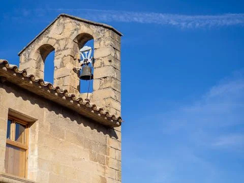 Stone bell tower with arched openings and clear blue sky Stock Photos