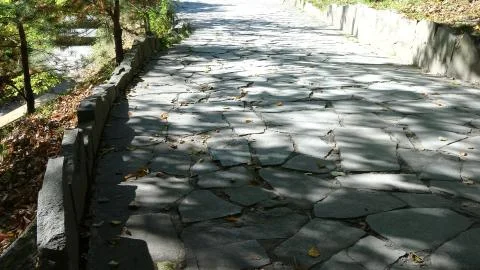 The Stone block walk path in the park with green grass background .Paving sla Stock Photos