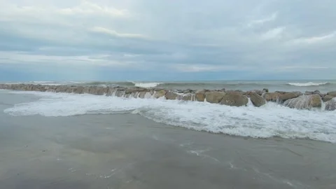 Stone breakwater on sandy seashore during storm Stock-Footage 170068181