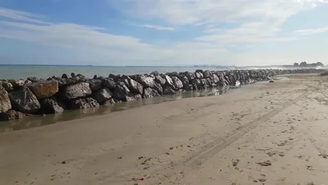 Stone breakwater on sandy seashore  Stock-Footage 168127227
