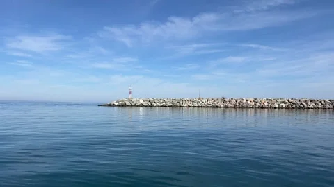 Stone breakwater with small lighthouse on calm Aegean Sea in Pieria, Greece Stock Footage 321068546