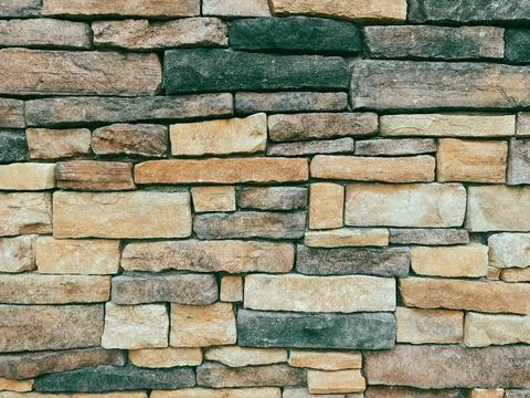 Stone brick building facade wall cut and irregular shapes rock structure Stock Photos