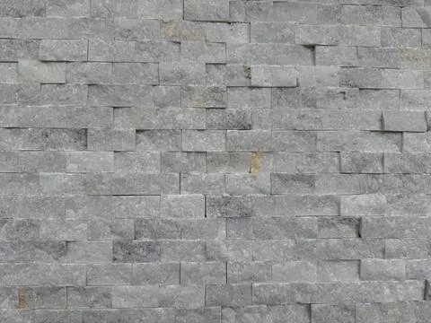 Stone brick wall texture creating rough gray background with unique pattern Stock Photos