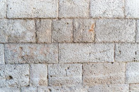 Stone brick wall texture with rough surface and aged weathered blocks in neutral Stock Photos