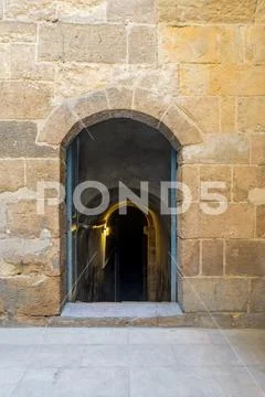Stone bricks wall with wooden door leading to old abandoned water cistern Stock Photos