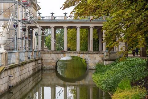Stone bridge with many columns stands over a water canal where maintenance to Stock Photos