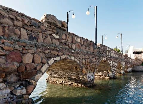 Stone bridge over a close-up perspective river Stock Photos