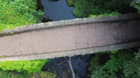 Stone bridge zoom out with runner in 4k above waterfall Stock-Footage 310944951