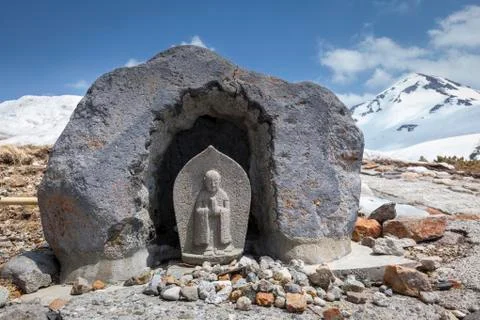 Stone buddhist statue in the mountains Stock Photos