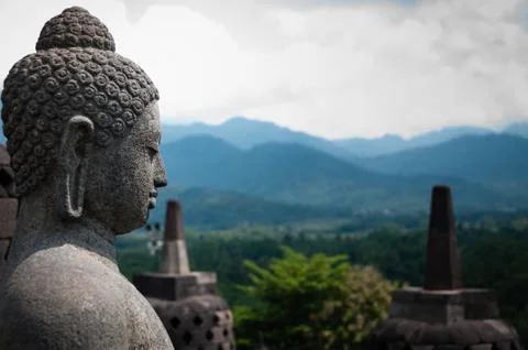 Stone budhha sideview in front of two stupas, Borobudur Stock Photos