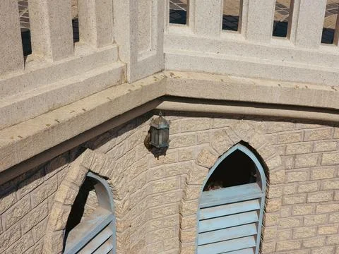 Stone building corner with arched windows and lantern Stock Photos