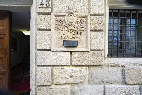 A stone building facade features a mailbox in San Marino Stock Photos