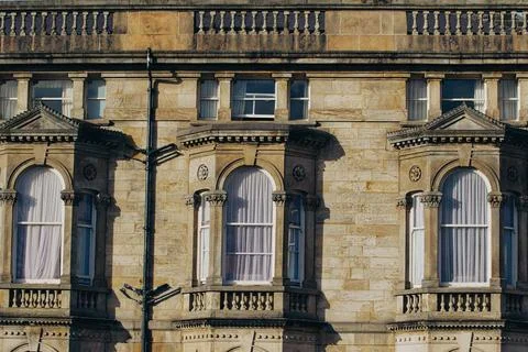 Stone Building Facade with Three Arch Bay Windows Beige stone building fac... Foto stock