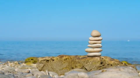 Stone cairn balancing on a secluded beach Stock Footage 322060810