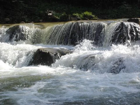Stone cascade with a waterfall on mountain river with streams of white wate.. Stock Photos