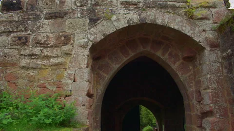 Stone castle gate opens to a green path outside. Video stock 309357758