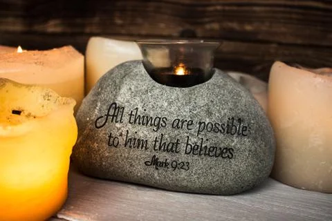 Stone with christian scripture with light candle Stock Photos
