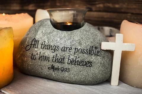 Stone with christian scripture with light candle cross Stock Photos