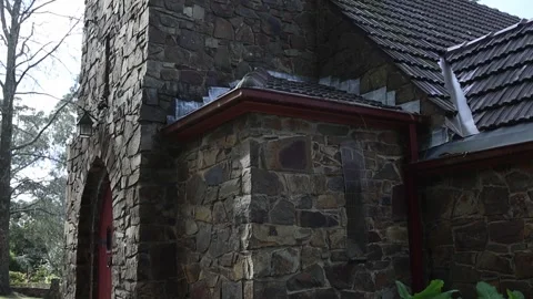 Stone church bell tower and red entrance door tilting down Stock Footage 341908724