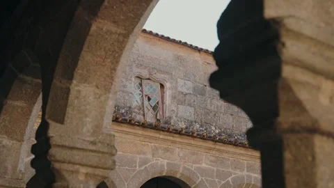 Stone church courtyard window framed by arches Stock Footage 327691013