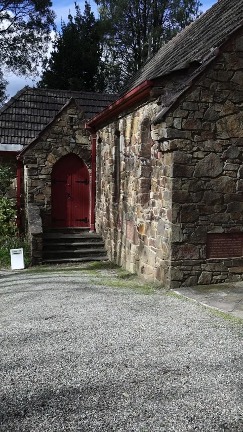Stone church with a red door in a rural setting Stock Footage 341906053