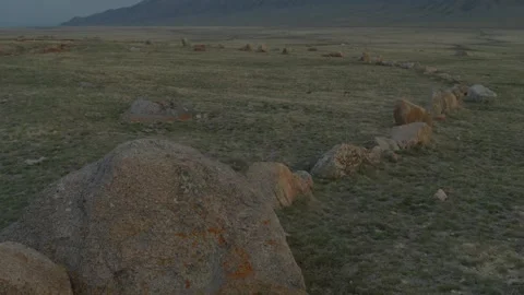 Stone circle in steppe landscape with mountains in distance Vidéo 333953111