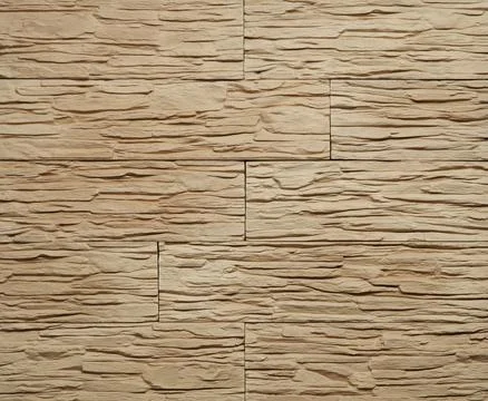 Stone cladding wall made of striped stacked slabs of yellow and brown rocks.. Stock Photos