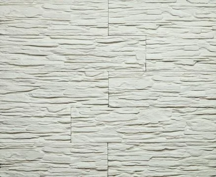 Stone cladding wall made of striped stacked slabs of white and grey rocks. .. Stock Photos