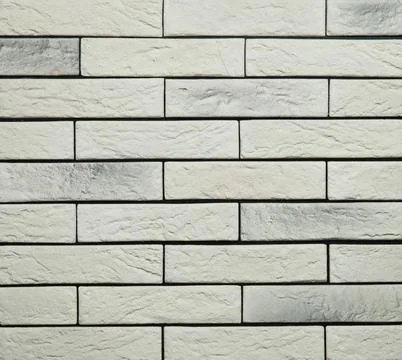 Stone cladding wall made of striped stacked slabs of white and grey rocks. .. Stock Photos