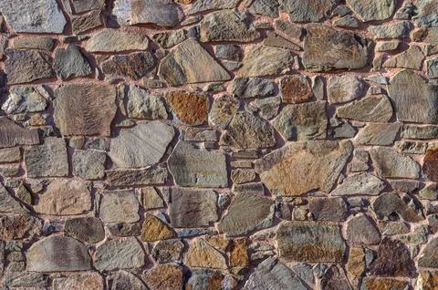 Stone cladding wall made of striped stacked slabs of natural brown rocks. P.. Stock Photos