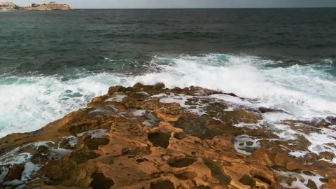 The stone cliff washed by the blue waves of the ocean Drone slow motion footage Stock Footage 233064909