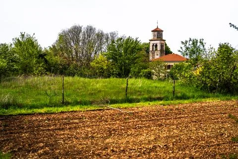 Stone Clock Tower Beyond Rural Meadow and Field Stock Photos
