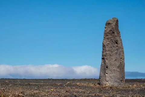 Stone column against a blue cloudy sky Stock Photos