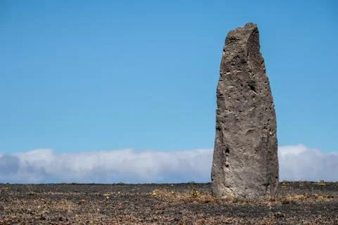 Stone column against a blue cloudy sky Stock Photos