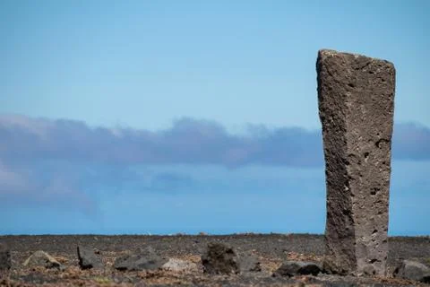 Stone column against a blue cloudy sky Foto stock