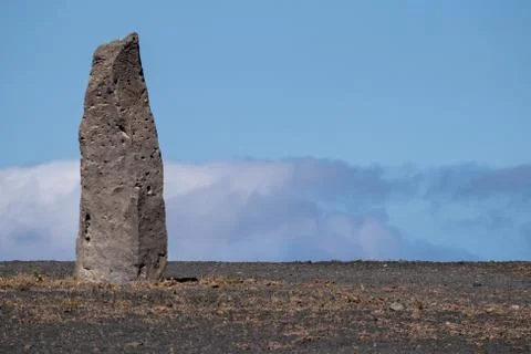 Stone column against a blue cloudy sky Foto stock