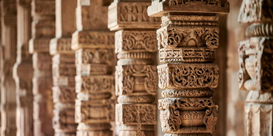 Stone columns with decorative bas relief of Qutb complex in South Delhi, In.. Stock Photos