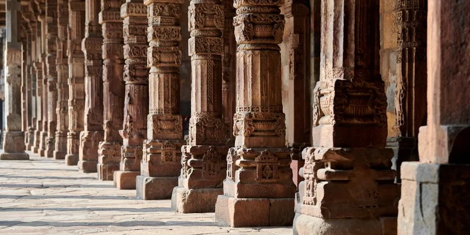 Stone columns with decorative bas relief of Qutb complex in South Delhi, In.. Stock Photos
