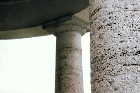 Stone columns with surface texture against bright sky background Stock Photos