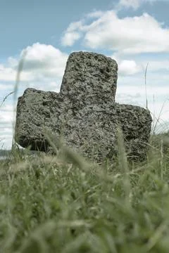Stone cross in the grass. Stock Photos