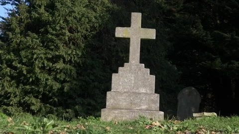 Stone Cross Monument in Cemetery Surrounded by Trees and Grass Stock-Footage 326798232