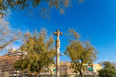 Stone cross monument in park under blue sky Stock Photos